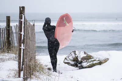 Woman going surfing during winter snow