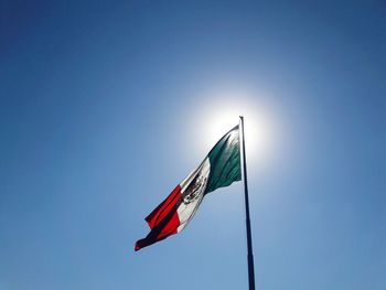 Low angle view of mexican flag against clear blue sky