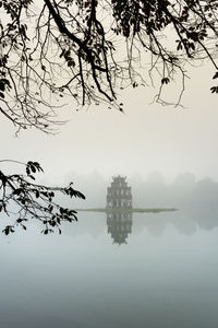 Reflection of tree in lake against sky