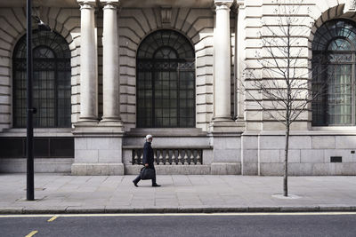 Uk, london, senior businessman walking on pavement in the city