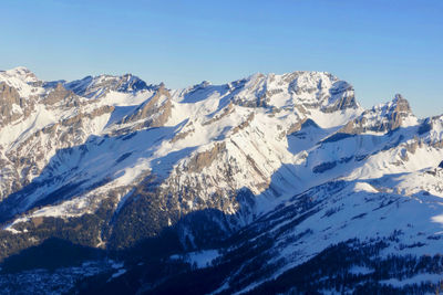 Scenic view of snowcapped mountains against clear blue sky