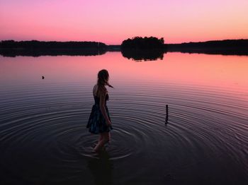 Woman in lake during sunset