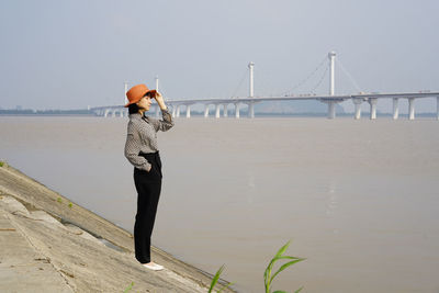 Full length of woman standing on bridge against sky