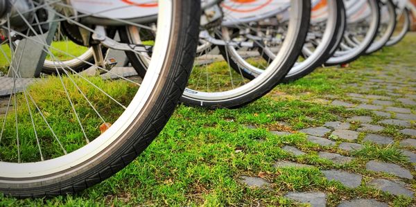 Cropped image of bicycles parked on field