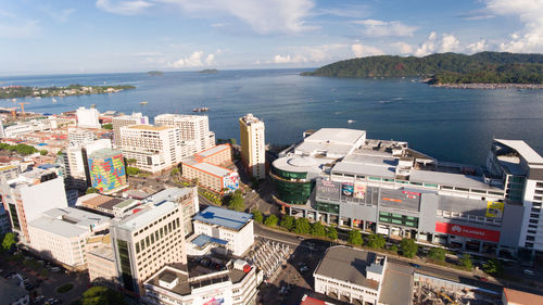 High angle view of buildings by sea against sky