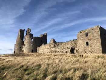 Low angle view of castle on field against sky