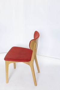 Close-up of empty chair on table against white background