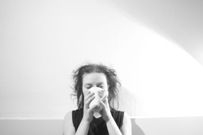 Young woman looking away against white background