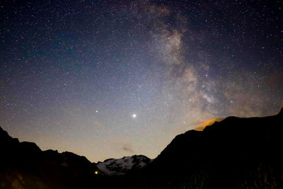 Scenic view of silhouette mountains against sky at night