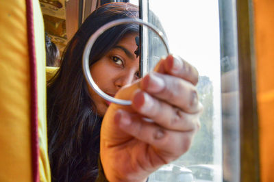 Portrait of woman holding glass window