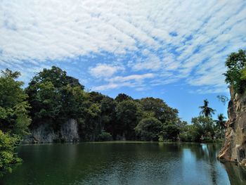 Scenic view of lake by trees against sky