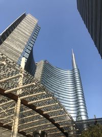 Low angle view of modern buildings against blue sky