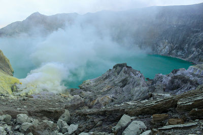 Scenic view of volcanic mountain against lake