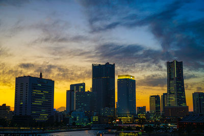 Modern buildings against sky during sunset