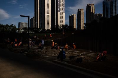 Group of people by modern buildings in city against sky