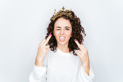 Portrait of woman gesturing while standing against white backgrounds