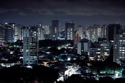 Illuminated cityscape against sky at night