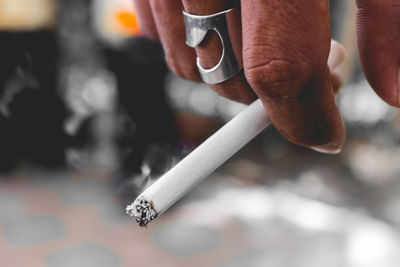 Close-up of hand holding cigarette