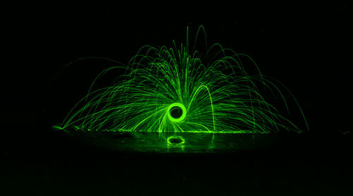 Person spinning wire wool at night