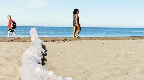 Woman standing on beach against sky