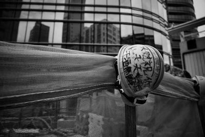 Close-up of person on railing against buildings in city