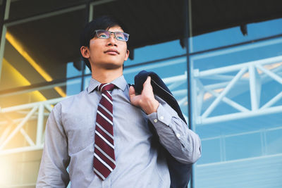 Low angle view of businessman standing against building