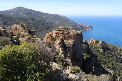 Scenic view of sea by mountains against sky