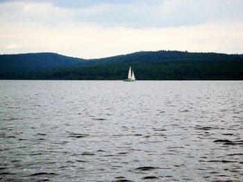 Boat sailing on sea against sky