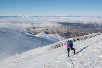 Man on snowcapped mountain against sky