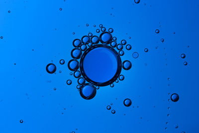 Full frame shot of water drops on blue surface