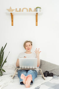 Young woman using digital tablet while sitting on table