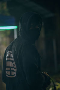 Rear view of man standing against black background