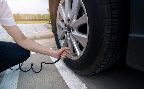 Woman inflates the tire. woman checking tire pressure and pumping air into the tire of car wheel. 