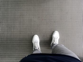 Low section of man standing on tiled floor
