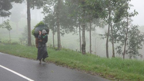 Man photographing car on road during rainy season