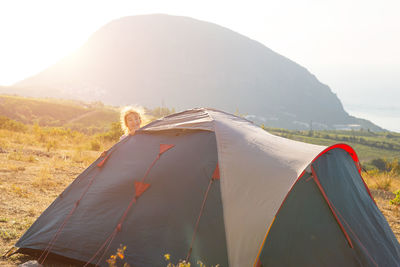 Tent on field by mountain against sky