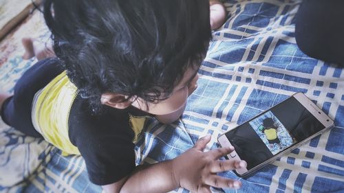 High angle view of boy using mobile phone at home