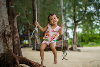 Front view of girl sitting on swing