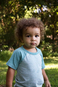 Portrait of boy standing against trees