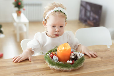 Deaf girl looking at tealight candle on table