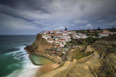 Panoramic view of sea and buildings against sky