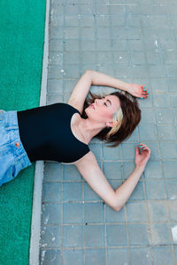 High angle view of woman sitting on footpath