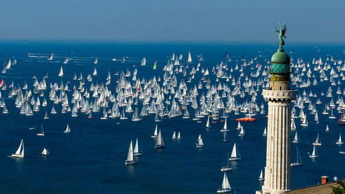 Sailboats in sea against buildings in city