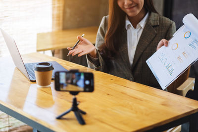 Midsection of woman holding coffee cup