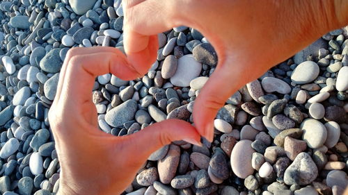 High angle view of person hand on pebbles