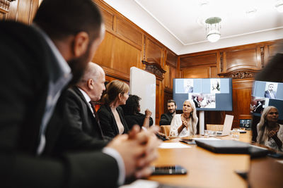 Female financial expert discussing with colleagues in conference at office