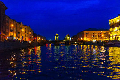 Illuminated buildings with waterfront at dusk