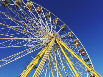 Low angle view of ferris wheel against blue sky