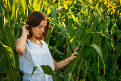 Young woman standing amidst plants