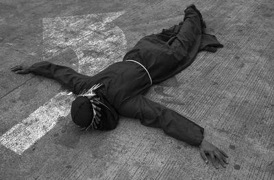 Low section of man sleeping on sidewalk